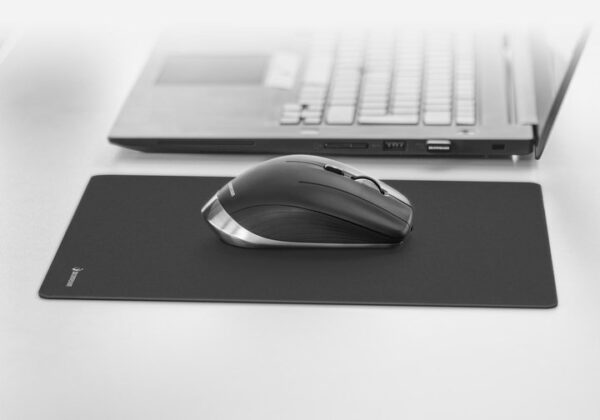 A mouse sitting on top of a black mousepad.